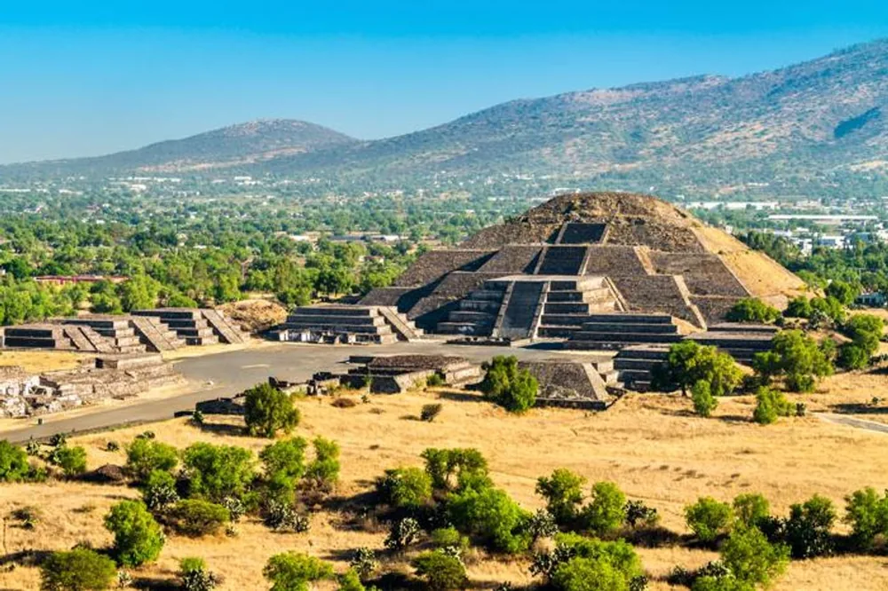 Green rainy-season valley around the Pyramid of the Moon under a clear morning sky on a Teotihuacan pyramids tour