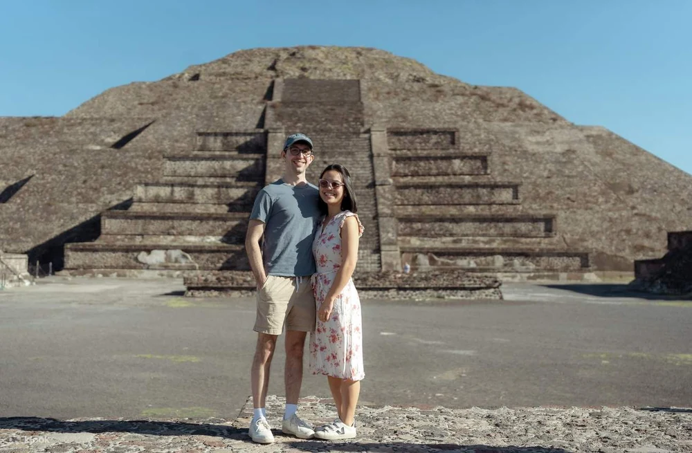 Couple standing at the base of the Pyramid of the Moon on a Teotihuacan pyramids tour from Mexico City
